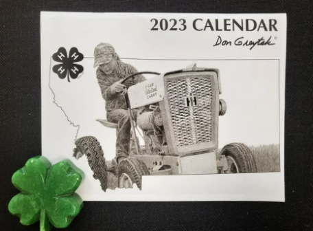 2023 Don Greytak calendar with a black and white photo of a person driving an old tractor inside an outline of the state of Montana with a 4-H clover in the corner.